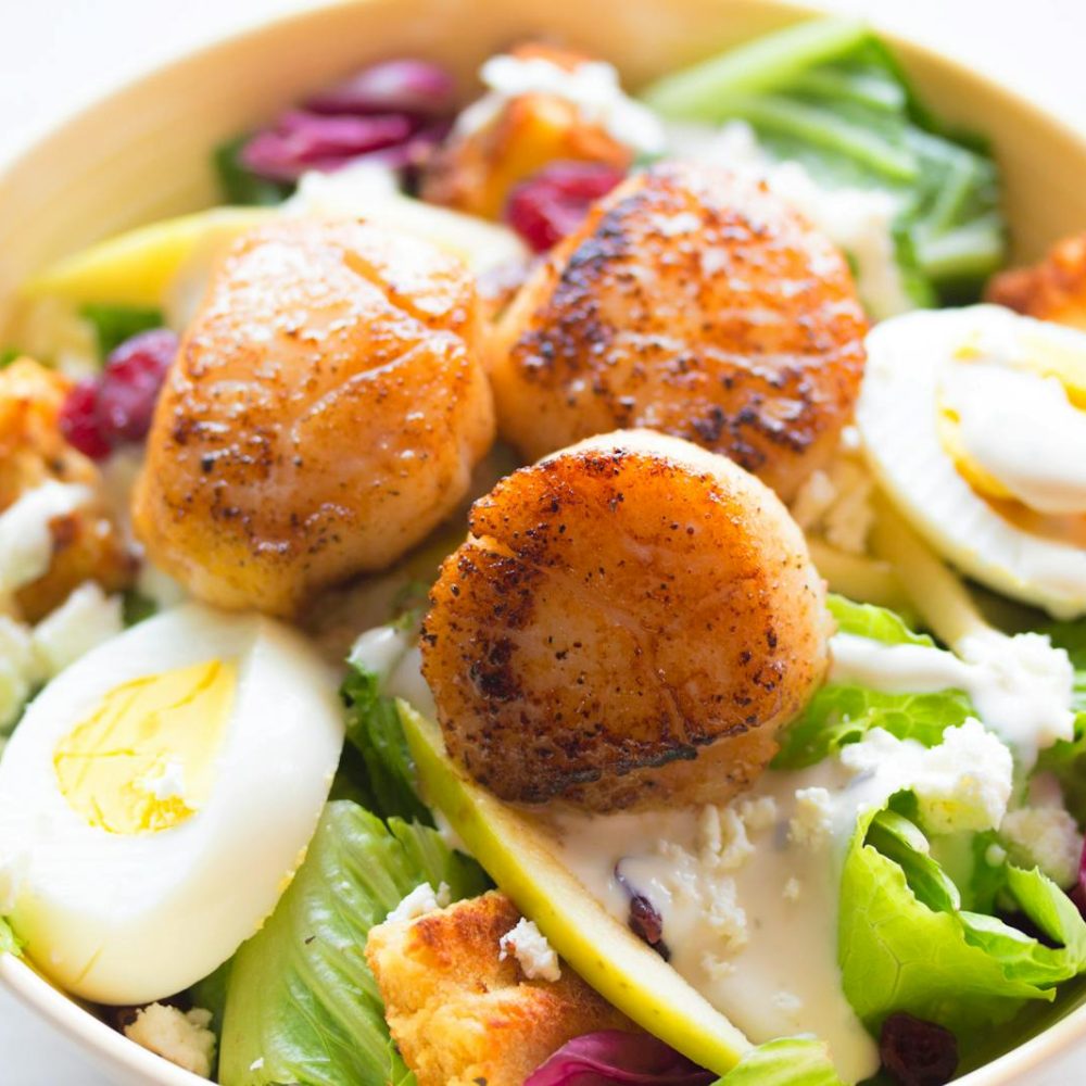 Delicious scallop salad with boiled eggs and fresh greens, perfect for a healthy meal.