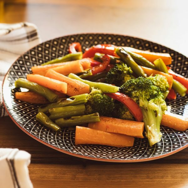 a plate of broccoli and carrots on a table
